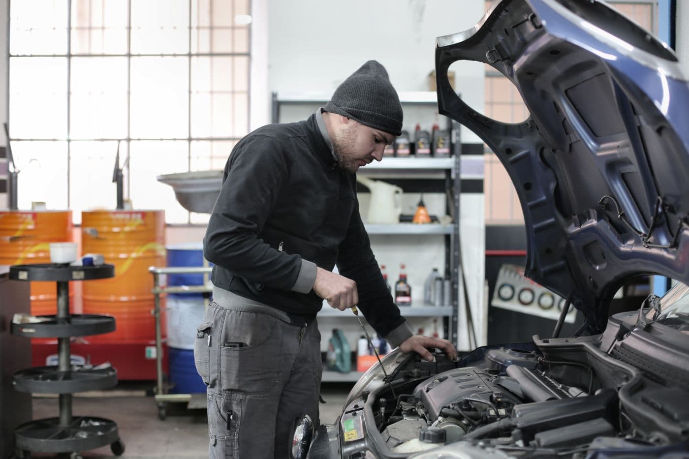 Technician servicing a car engine in our workshop